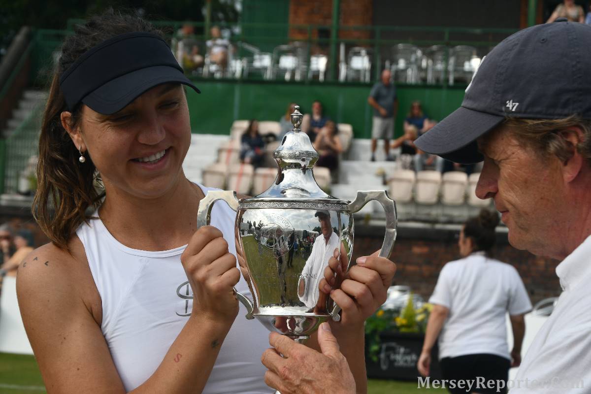 Tennis player signing a ball.